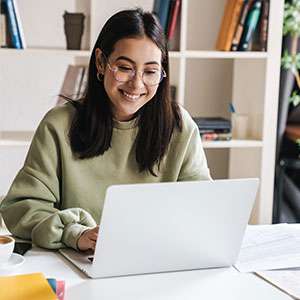 Student reading book in library wearing mask